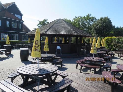 a group of picnic tables with yellow umbrellas on them at Oyster Fleet Hotel in Canvey Island