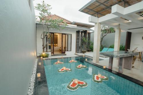 an infinity pool in the middle of a villa at The Tukad Villa in Seminyak