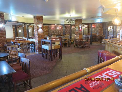 a restaurant with tables and chairs and a bar at Oyster Fleet Hotel in Canvey Island