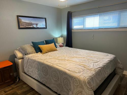a bedroom with a large bed with blue and yellow pillows at Casada in Las Vegas