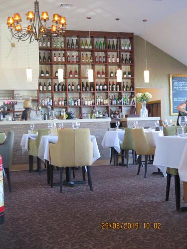 a restaurant with tables and chairs and a bar at Oyster Fleet Hotel in Canvey Island