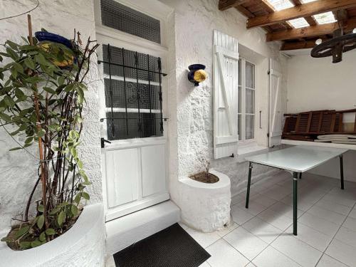 Cette chambre blanche dispose d'une table et d'une fenêtre. dans l'établissement Maison 4 pièces LA ROCHELLE - LR000-015, à La Rochelle