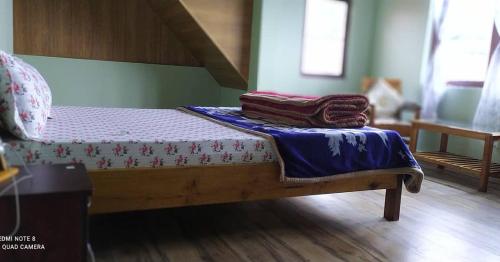 a bed with two blankets sitting on top of it at The Nest Farmhouse in Sāmthar