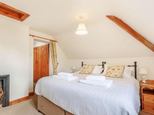 a bedroom with a large bed with white sheets at Robin's Nest in Craven Arms