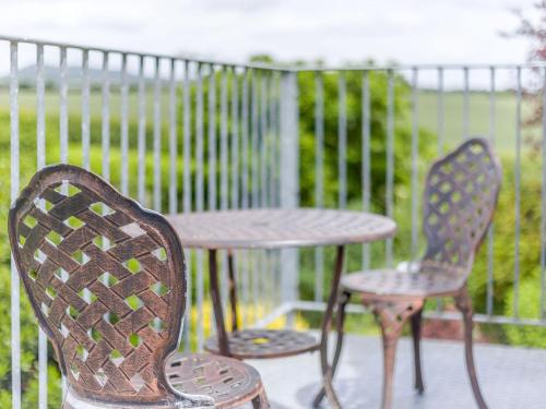 two chairs and a table on a patio at Robin's Nest in Craven Arms
