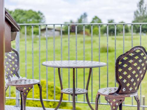 two chairs and a table on a balcony with a table at Robin's Nest in Craven Arms