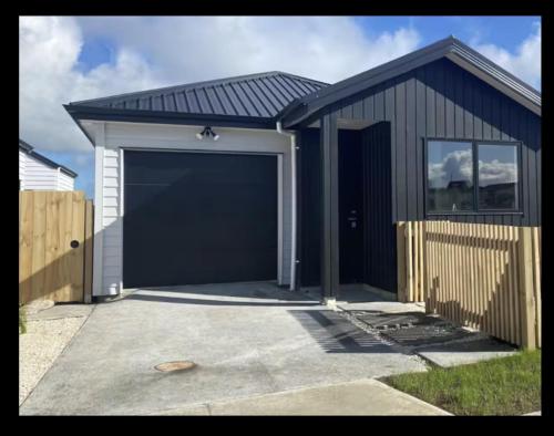 a garage with a large black garage door at Cozy Room in Papakura Auckland in Auckland