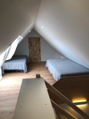 - une chambre mansardée avec 2 lits et une table dans l'établissement Rue Bara, à Roscoff
