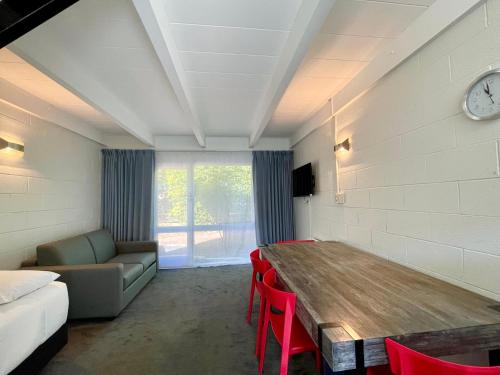 a room with a table and a couch and a bed at Mount Eden Motel in Auckland