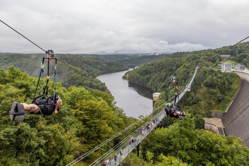 a group of people on a suspension bridge over a river at Schlosshotel Blankenburg in Blankenburg