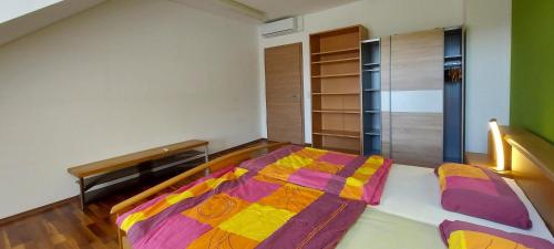 a bedroom with a bed with a colorful comforter at Ferienwohnung Ragwurz in Blieskastel