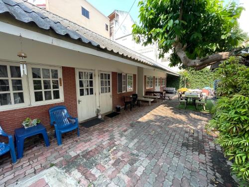 a patio of a house with blue chairs and tables at Thai-Tae Guesthouse Hua Hin in Hua Hin