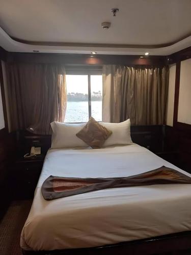a large bed in a room with a window at الباخرة ريفر بوت river boat in Cairo
