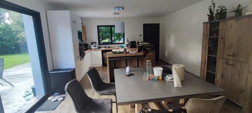 une cuisine avec une table et des chaises dans une pièce dans l'établissement Maison 4 chambre 11personnes grand jardin, à Donges
