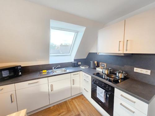 a kitchen with white cabinets and a sink at EcoCube 3 Haren - Maisonette, 2Schlafzimmer, Waschmaschine in Bahnhof Haren