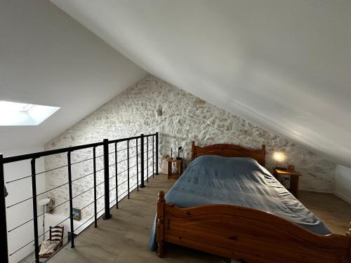- une chambre mansardée avec un lit en bois dans l'établissement Charmante maison rénovée près du centre - FR-1-709-91, à Fouras
