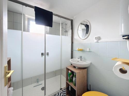 a bathroom with a glass shower and a sink at Le Blériot in Sangatte