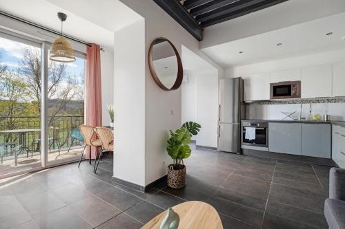 une cuisine et un salon avec une grande fenêtre dans l'établissement Superbe T3 avec vue imprenable sur le Rhône, à Caluire-et-Cuire