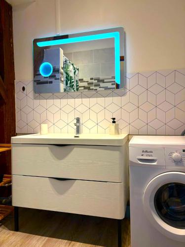 une salle de bain avec un lavabo et une machine à laver dans l'établissement proche gare et centre-ville, parking gratuit et facile, wifi, à Châlons-en-Champagne