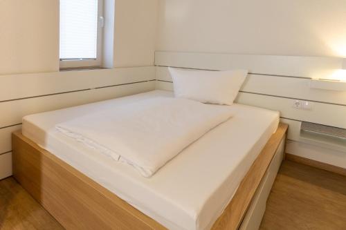 a bed in a small room with a white mattress at Feriendorf Slawitsch in Bad Sulza