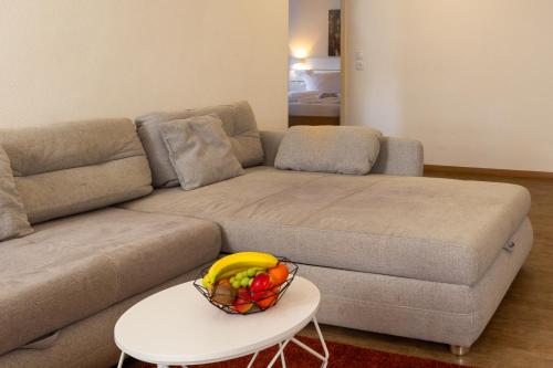 a living room with a couch and a bowl of fruit on a table at Feriendorf Slawitsch in Bad Sulza
