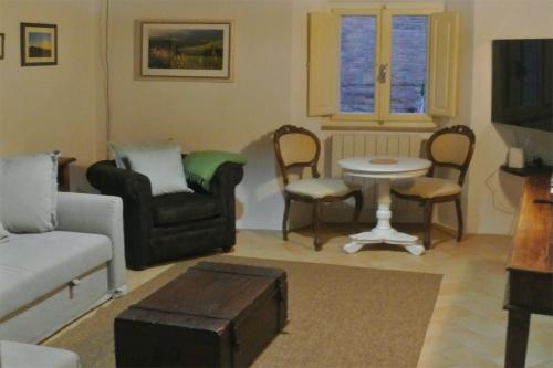 a living room with a couch and a table and chairs at Casa Alberi in Volterra