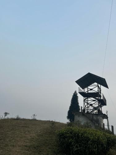 a tower on top of a hill in a field at Lazim Homestay & Tea Spot in Mirik