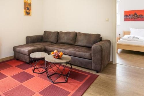 a living room with a brown couch and two tables at Feriendorf Slawitsch in Bad Sulza