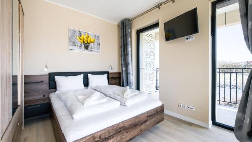 una camera da letto con un letto grande con una TV a parete di Baltic Infinity, Sun & Snow a Międzyzdroje