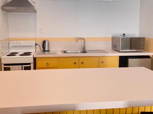 a kitchen with a sink and a microwave at Mount Eden Motel in Auckland