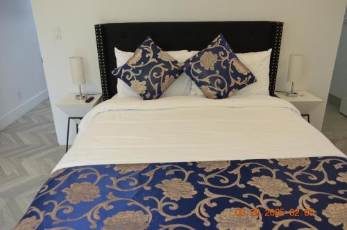 a bed with blue and white sheets and pillows at Dimond Abode Vacation Home #2 Oakland Dimond District in Oakland