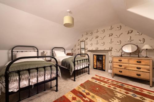 a bedroom with two beds and a fireplace at Old Duffus Farmhouse in Duffus