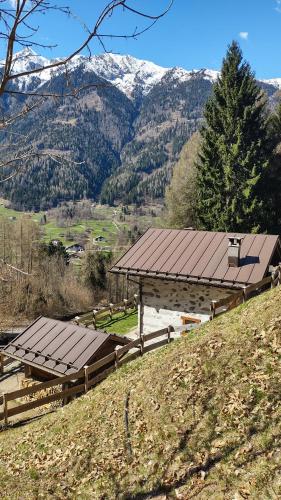 a pavilion on a hill with mountains in the background at Chalet Maso Salam in Bocenago