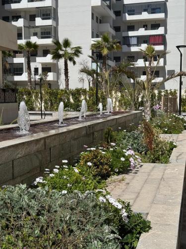 a garden with statues in the middle of a building at Évasion zen près de Casablanca - Vue imprenable sur le parc et la plage de l'Éco City Zenata in Aïn Harrouda