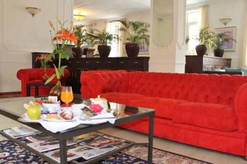 a red couch in a living room with a coffee table at Hotel Riviera Varazze in Varazze