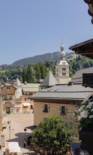 a view of a town with a building and a church at Hotel Mont Blanc Megève in Megève