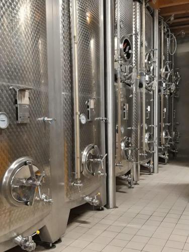 a row of wine tanks in a brewery at Gîtes Thirion in Saint-Hippolyte