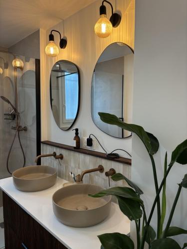 une salle de bain avec deux lavabos et deux miroirs dans l'établissement Nomad, à Bordeaux