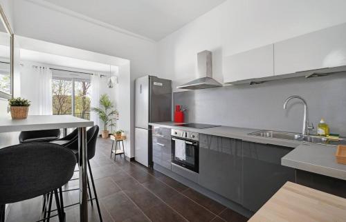 une cuisine avec un évier et une cuisinière four supérieur dans l'établissement Havre de paix pour 4, clim et balcon, Caluire, à Caluire-et-Cuire