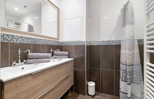 une salle de bain avec un lavabo et un miroir dans l'établissement Havre de paix pour 4, clim et balcon, Caluire, à Caluire-et-Cuire