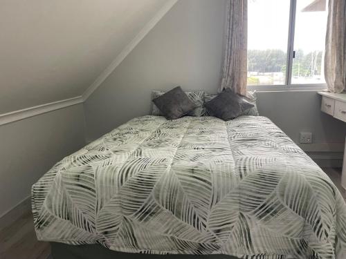 a bed in a bedroom with a large window at 2 bedroom Apartment on the Bay in Richards Bay