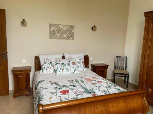 une chambre avec un lit avec un couvre-lit fleuri dans l'établissement Bâtisse au cœur d'un vignoble, à Montfrin