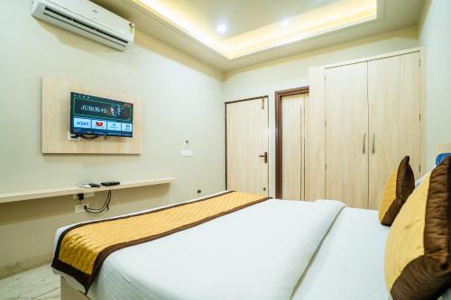 a bedroom with a bed and a tv on the wall at HOTEL SNOOZE in Jaipur