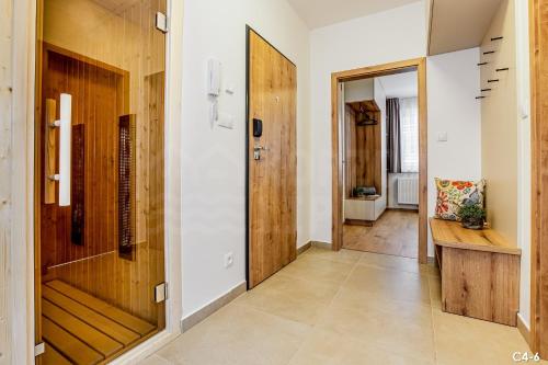 a hallway with white walls and a wooden door at KORZO LIPNO C in Lipno nad Vltavou