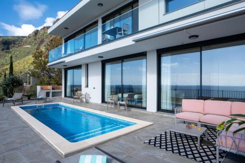 a house with a swimming pool and windows at Villa La Perla by LovelyStay in Paul do Mar