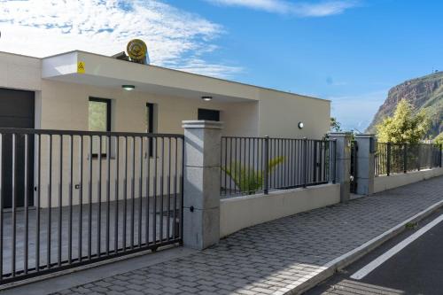 a white house with a fence and a road at Villa La Perla by LovelyStay in Paul do Mar