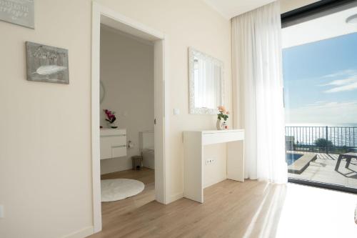 a white living room with a view of the ocean at Villa La Perla by LovelyStay in Paul do Mar