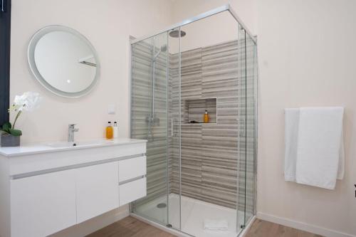 a bathroom with a shower with a sink and a mirror at Villa La Perla by LovelyStay in Paul do Mar