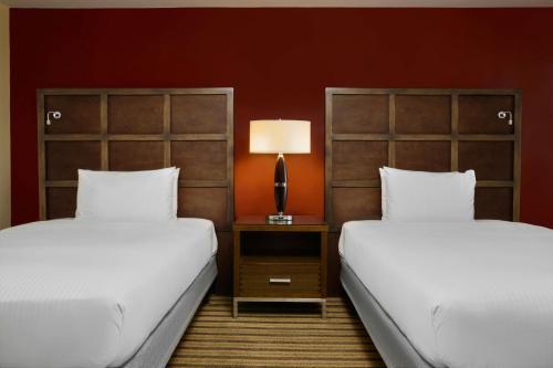 a room with two beds and a lamp on a night stand at Renaissance Caracas La Castellana Hotel in Caracas