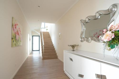 a white hallway with a staircase and a vase of flowers at Villa La Perla by LovelyStay in Paul do Mar